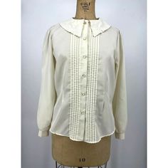 "Ann Chabrol Blouse Shirt Ivory White Pointed Flat Collar  Medium Embroidered Pointed Flat Collar Tuxedo Pleat Front Button Up Long Sleeve Button Cuffs Retro Modest Style 100% Polyester Measurements Chest 42\" Waist 39\" Length 24.5\"" Cream Peter Pan Collar Blouse For Spring, Cream Button-up Office Top, Cream Cotton Button-up Blouse, White Collared Blouse With Placket, Cream Long Sleeve Tops With Buttons, Long Sleeve Cream Tops With Buttons, White Blouse With Collared Neckline And Placket, Classic Cream Button-up Top, Classic Cream Collared Shirt