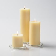 three white candles sitting on top of each other