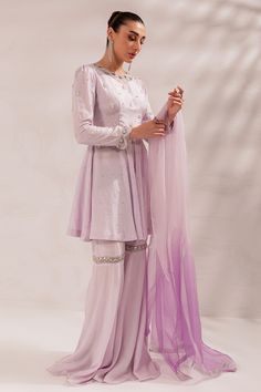 Pakistani Eid Dress in Lilac Gharara and Peplum Style is a stunning masterpiece that will give you a head-turning look on the festive occasion. This beautiful Gharara Dress is embellished with crystals, Resham, and sequins, making it an epitome of beauty and grace. Detailed Description: SKU: PS1831 Detailing: Embroidery, Threads, Crystals, Resham, Sequins Color: Lilac Fabric: Raw Silk, Organza Design: Fully Embroidered dress Event: Festive, Party wear Gharara Dress, Lilac Fabric, Eid Dress, Dress Event, Eid Dresses, Embroidery Threads, Peplum Styling, Peplum Styles, Wedding Prep