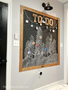 a chalk board is hanging on the wall in front of a door with christmas decorations