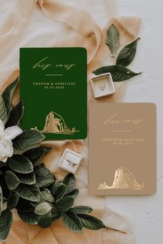 the wedding stationery is surrounded by greenery and gold foil stampers, including an envelope