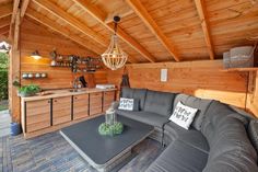 a couch and table in a room with wood paneling on the walls, wooden ceiling