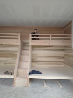 there is a woman standing on top of the bunk beds in this room that are built into the wall