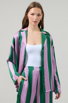 How charming is this stripped button-down shirt with a purple and green stripped pattern! This classic shirt has oversized fit with dropped shoulders and a collared neckline. Wear it buttoned up or unbutton it and pair it with the matching bottoms. - Striped- Loose fit- Button up- Drop shoulder- Color: Green MultiSize + Fit - Model is 5'8" and wearing size XS- Measurements taken from size S - Chest: 21 1/2"- Length: 27" Fabric Self: 100% Polyester Style Number STT17310 Green Relaxed Button-up Top, Casual Green Shirt With Vertical Stripes, Green Vertical Striped Shirt For Summer, Green Vertical Stripes Button-up Shirt, Green Vertical Striped Summer Shirt, Oversized Green Button-up Shirt, Green Loose Fit Button-up Shirt, Spring Green Shirt With Vertical Stripes, Green Vertical Stripes Shirt For Spring