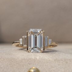 an emerald cut diamond ring with three baguets