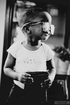 a little boy wearing glasses and holding a book