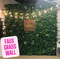 a green wall with lights and a sign that says faux grass wall next to it