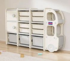 a white shelf with several bins on top of it in a room next to a wall