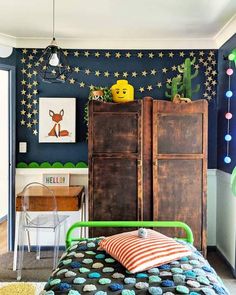 a bedroom decorated in blue and green with stars on the wall