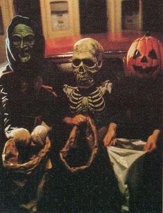 two skeletons sitting next to each other in front of pumpkins and jack - o'- lanterns