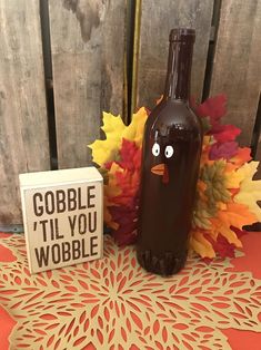 a bottle with a face on it sitting next to a sign that says gobble i'll you wobble