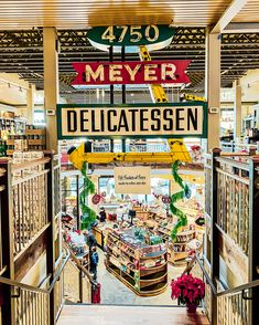 the interior of a store with large signs and decorations on the walls, including a sign that says mayer delicatessen