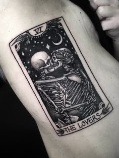 a skeleton tarot card tattoo on the back of a man's arm,