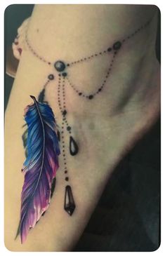 a woman's foot with a tattoo on it and a feather hanging from the ankle