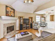 a living room filled with furniture and a flat screen tv on top of a fireplace