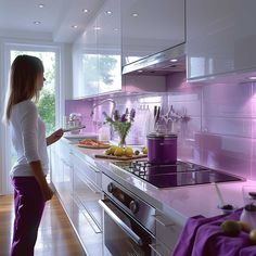 a woman standing in a kitchen next to a stove top oven and counter with food on it