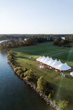 an aerial view of a large tent set up on the edge of a lake