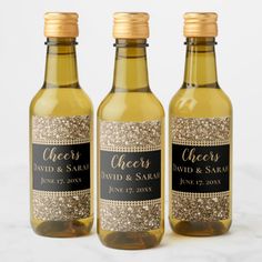 three bottles with gold glitter and black labels on them, one is labeled'cheers david & sarai '