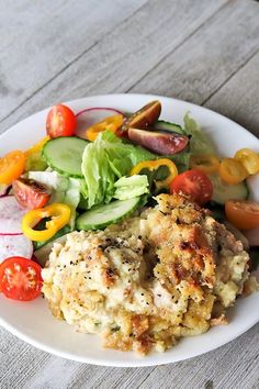 a white plate topped with meat and veggies on top of a wooden table