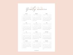 a pink and white calendar with gold foil lettering on the front, next to a peach background