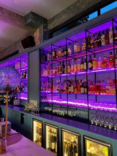 a bar with purple lighting and liquor bottles