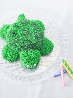 there is a cake shaped like a turtle on the plate with two straws next to it