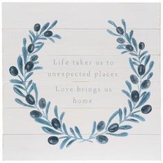 a white sign with blue leaves on it that says, life takes us to unexpected places love brings us home