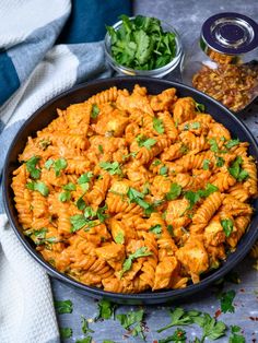 a bowl filled with pasta and garnished with cilantro next to other ingredients