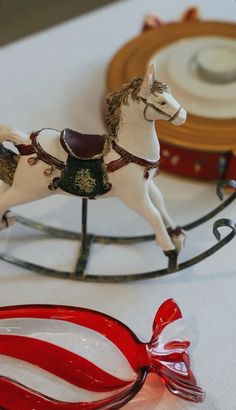 a toy horse on a sleigh with a candy cane in the foreground