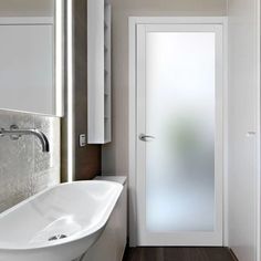 a bathroom with a sink and mirror next to a white door in the middle of it