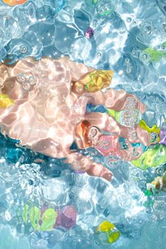 a baby in the water with lots of bubbles on it's head and arms