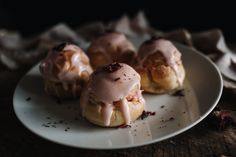 three pastries with icing on a white plate