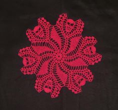 a red doily on a black background