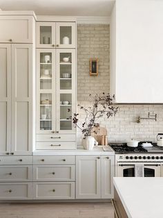 a kitchen with white cabinets and counter tops