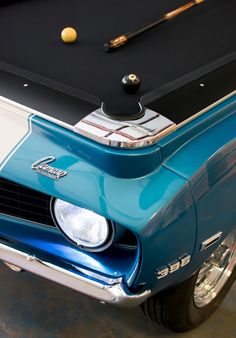 the front end of an old car with a pool table