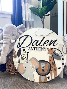 an elephant, giraffe and zebra are sitting in front of a sign that says dalen anthony