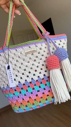 a crocheted bag with tassels and a tag hanging from the handle