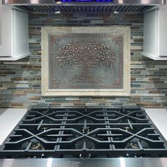 a stove top oven sitting inside of a kitchen next to a wall mounted tile design