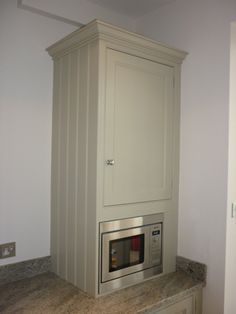 a microwave built into the side of a cabinet