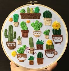 a person holding up a cross stitch embroidery kit with potted plants and flowers on it