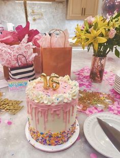 a birthday cake sitting on top of a table covered in flowers and confetti