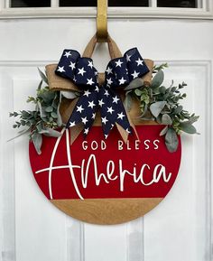 a patriotic door hanger with the words godless america painted on it and an american flag bow