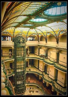 the inside of an old building with many windows and glass ceiling lights in it's center