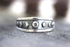 "This listing is for one sterling silver moon phase celestial stacking ring. Wear solo or with stacking bands for an irresistibly enchanting and boho set. I make these with 18 gauge sheet metal pushed into a steel die in my hydraulic press- pushing the metal into the design so it is three dimensional with the moon phases and border raised out. This is then sawed out and fired onto sturdy 10 gauge sterling silver half round wire. This is a substantial ring, not flimsy. Makes a great gift for any Mystical Adjustable Moon Phase Rings, Adjustable Moon Shaped Bohemian Rings, Bohemian Moon Shaped Adjustable Rings, Bohemian Adjustable Moon-shaped Rings, Bohemian Open Ring With Moon Phase Detail, Bohemian Moon Phase Open Ring Jewelry, Bohemian Open Ring With Moon Phase, Adjustable Moon Shape Rings With Moon Phase Detail, Bohemian Silver Moon Charm Ring