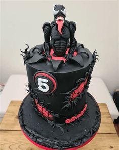 a black and red cake with a monster on top