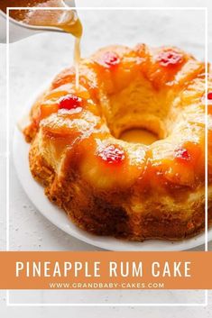 a pineapple rum cake is being drizzled with syrup on a white plate