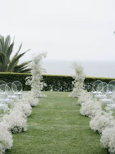 an outdoor wedding setup with white flowers and chairs