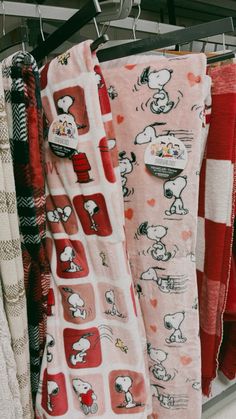 towels are hanging on a rack in a store, with snoopy characters all over them