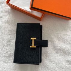 Authentic Hermes Mini Wallet In Mysore Goatskin -Noir/Black Color With Gold Hardware -B Stamp - Leather Tab With "H" Closure - Change Purse With Snap Closure - 2 Credit Card Slots ** Very Hard To Get Color And Leather Made In France Metallic Finish: Gold Plated Dimensions: L 10.8 X H 7.5 X D 0.4 Cm Hermes Wallet Women, Black Business Wallet With Gold-tone Hardware, Business Black Wallet With Gold-tone Hardware, Designer Black Wallet With Gold-tone Hardware, Designer Black Wallets With Leather Lining, Designer Black Wallets With Gold-tone Hardware, Luxury Black Wallets With Gold-tone Hardware, Luxury Black Wallets For Daily Use, Black Evening Wallets With Gold-tone Hardware