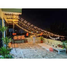 an outdoor seating area with lights strung over it